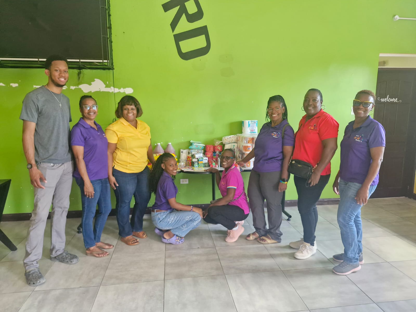 Childcare Ministry volunteers presenting household care supplies