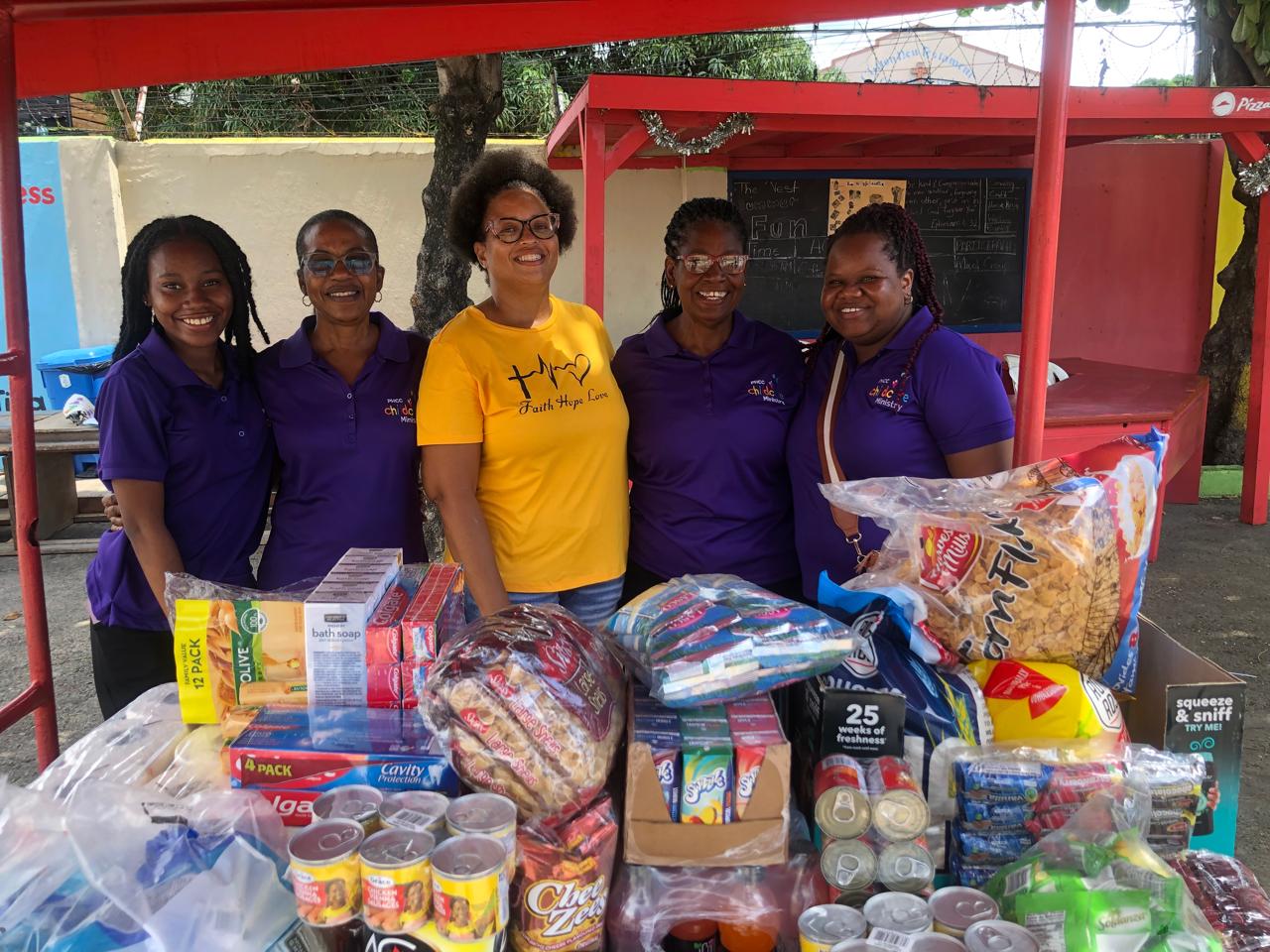 Childcare Ministry volunteers with donated food and care supplies