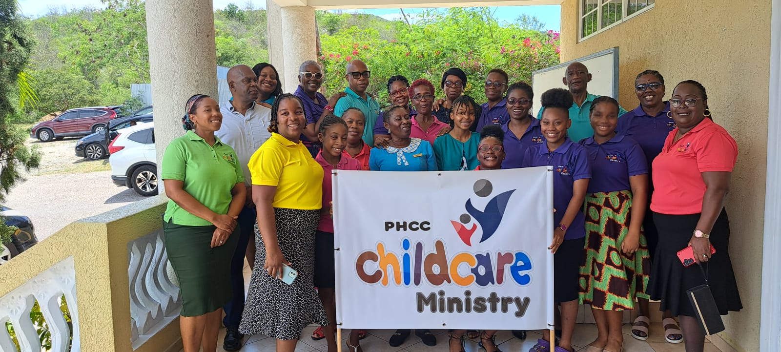 PHCC Childcare Ministry team holding their ministry banner