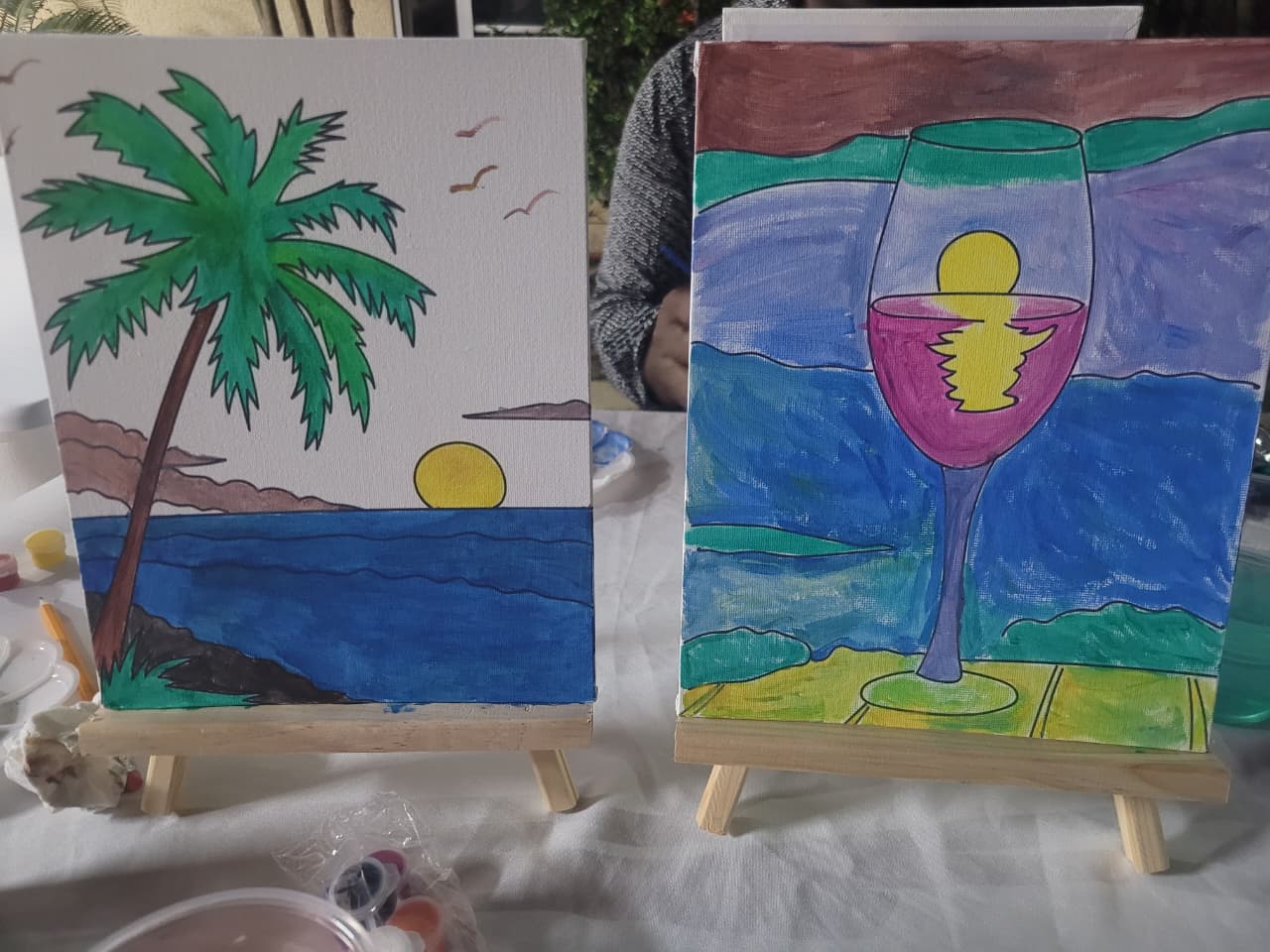 Two completed paintings displayed together on tabletop easels