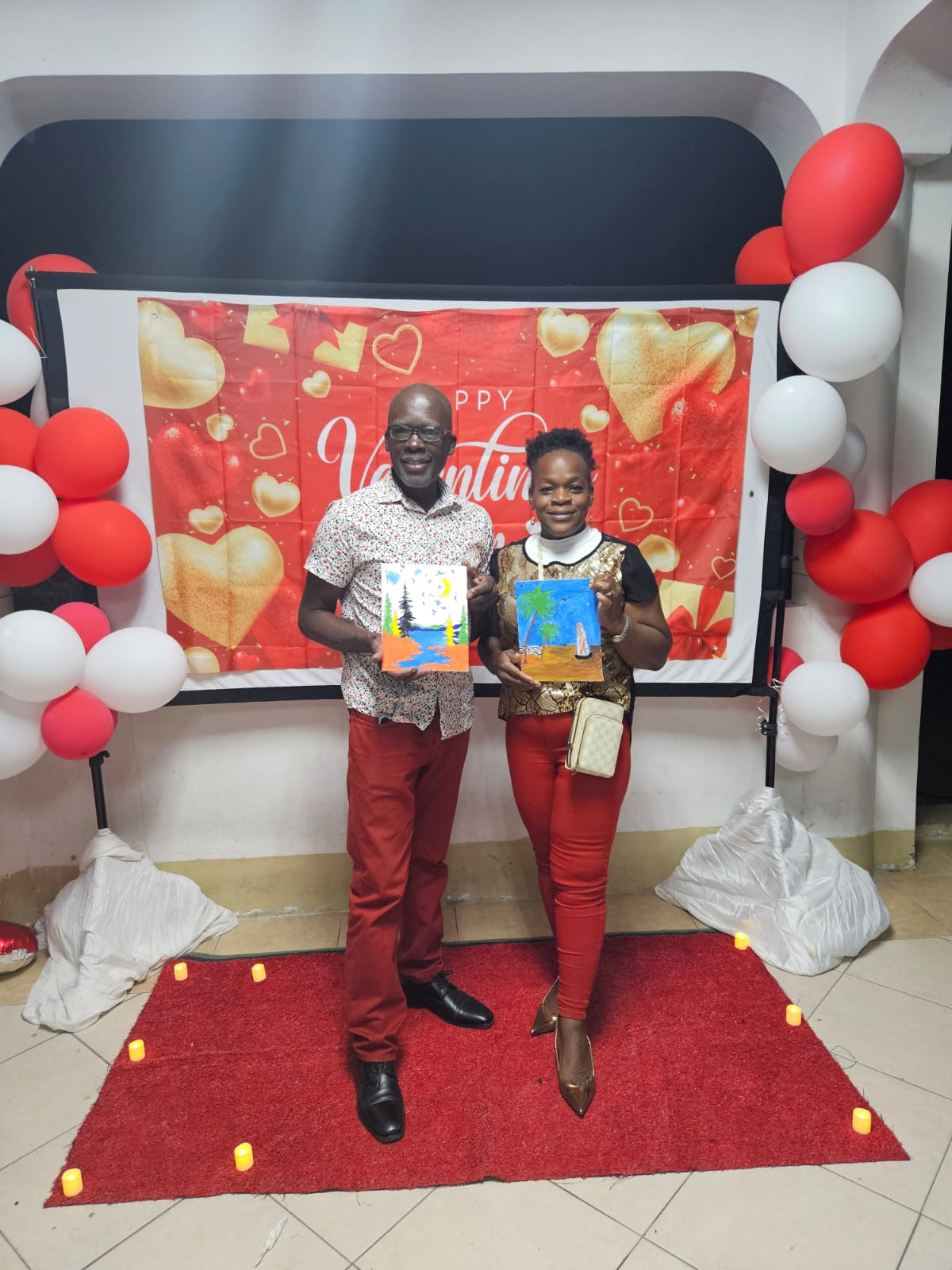 A couple presenting their completed paintings at the Valentine gathering
