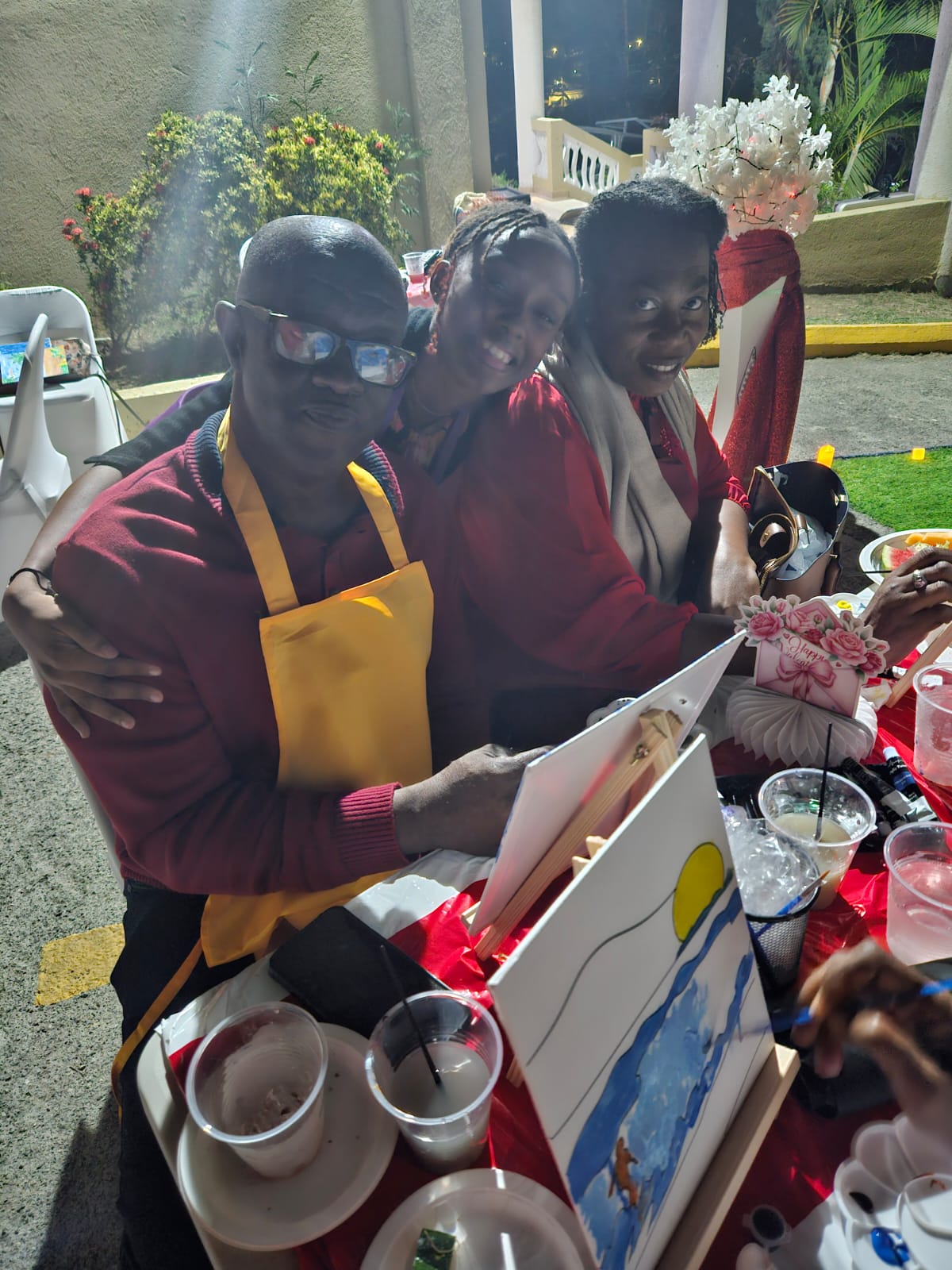 Participants smiling together at a painting table