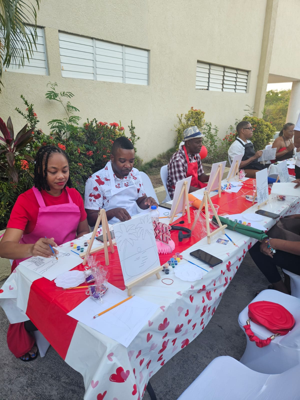 Couples painting at decorated outdoor tables beside the church