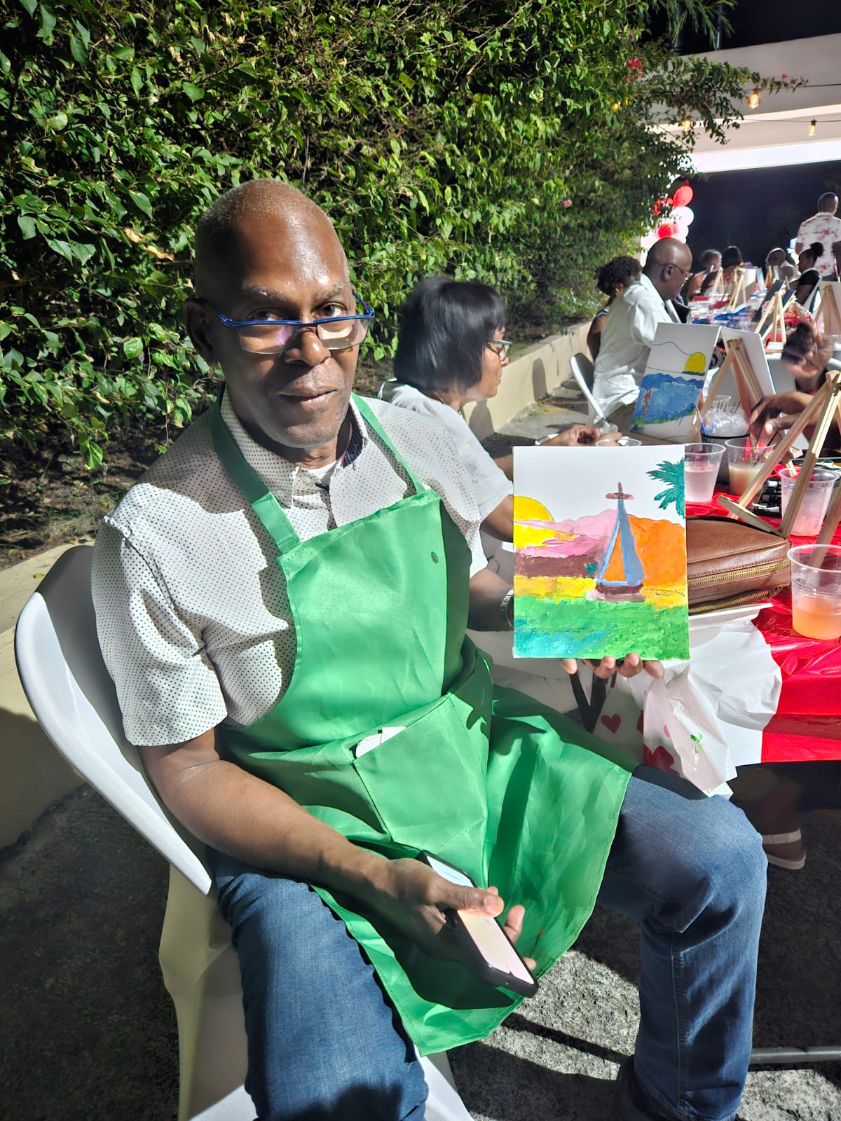 A participant presenting his completed painting