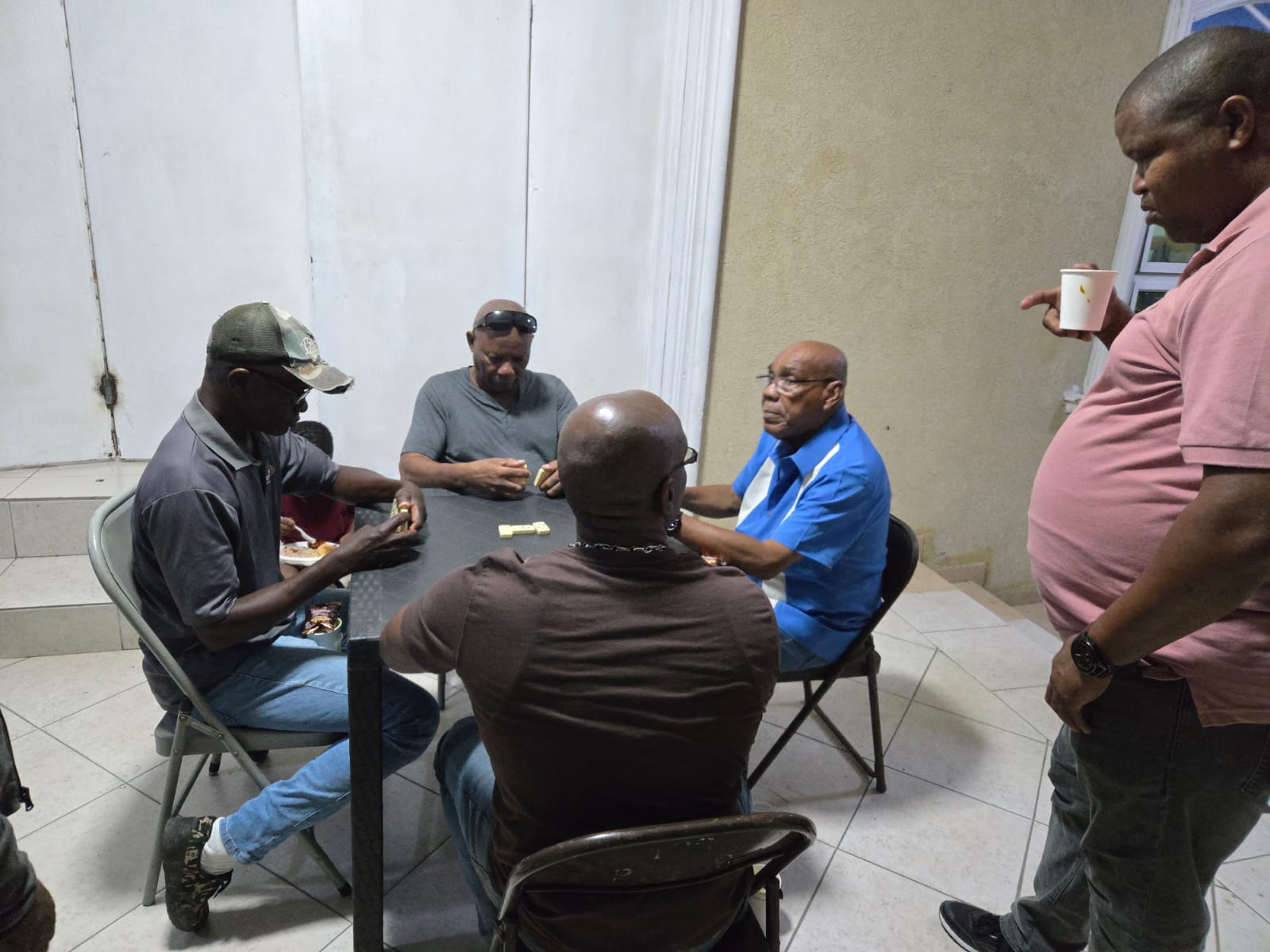 Men sharing conversation and a game of dominoes indoors