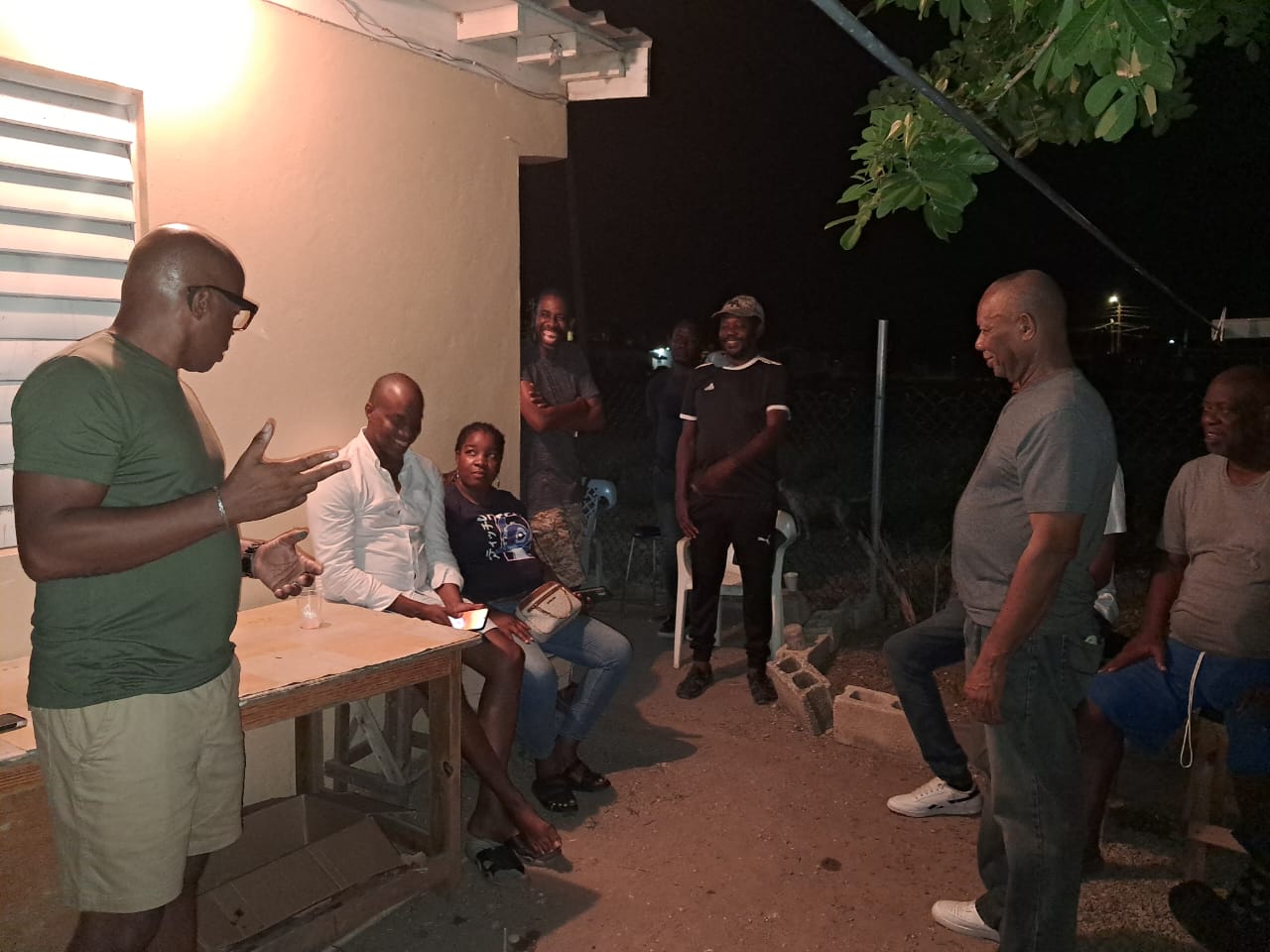Men in conversation during an outdoor evening gathering