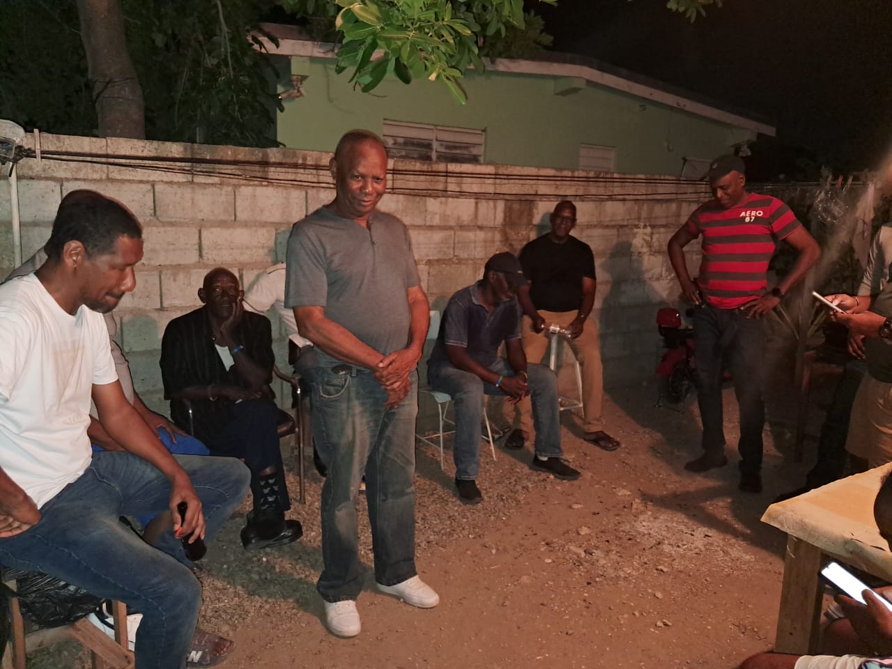 Men gathered outdoors for conversation and fellowship at night