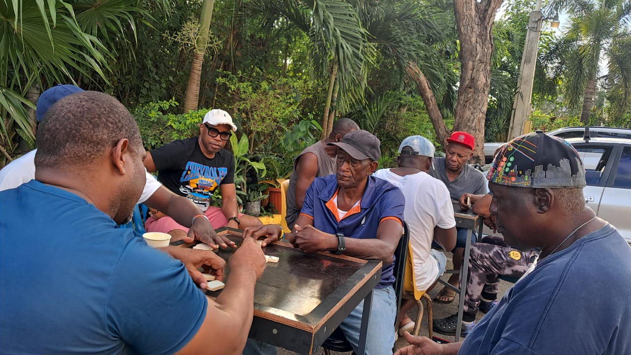 Men gathered around a table for fellowship outdoors