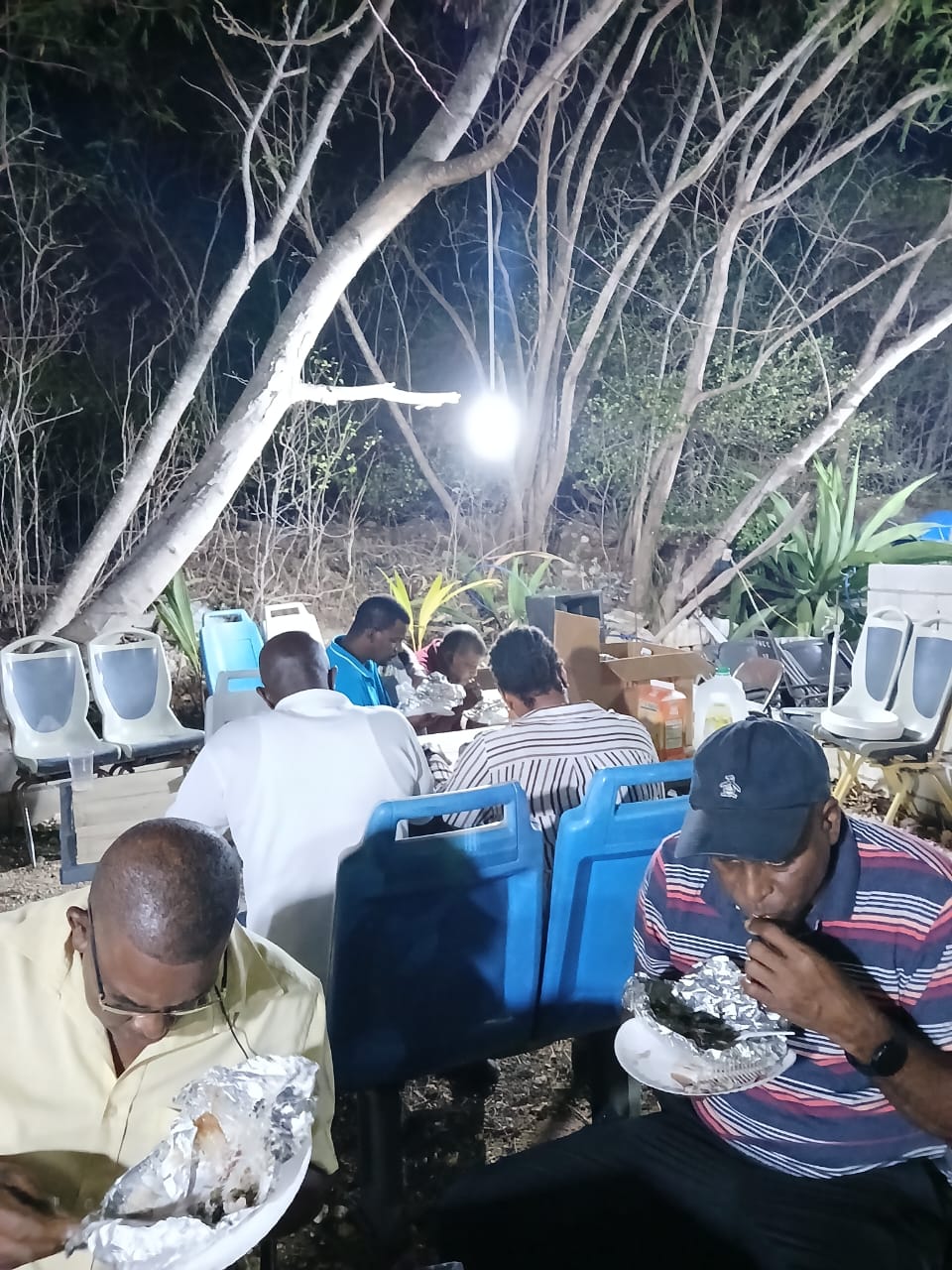 Men enjoying a shared meal during an outdoor fellowship