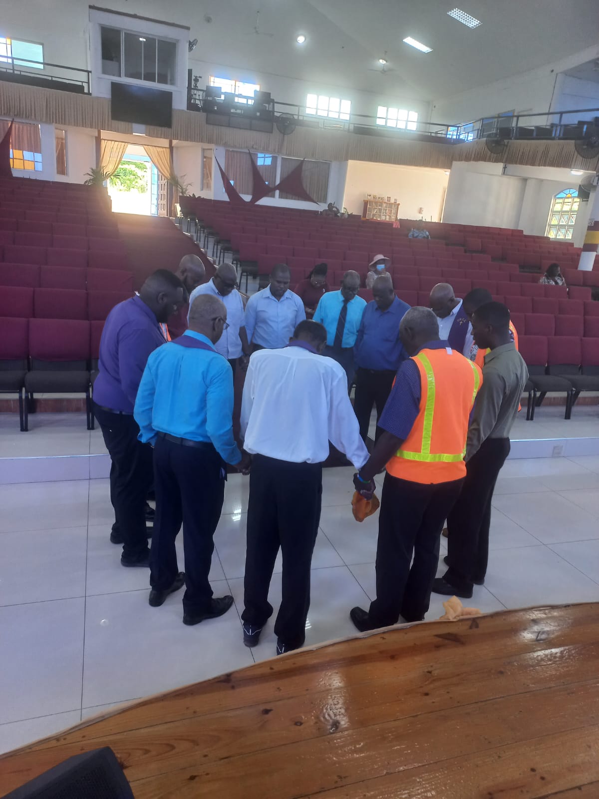 Men joining hands in prayer inside the sanctuary