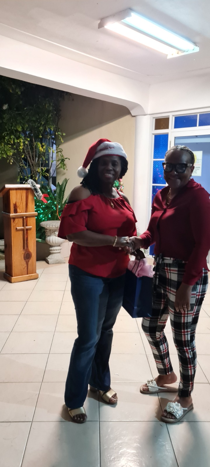Two women exchanging a gift during a Christmas fellowship programme