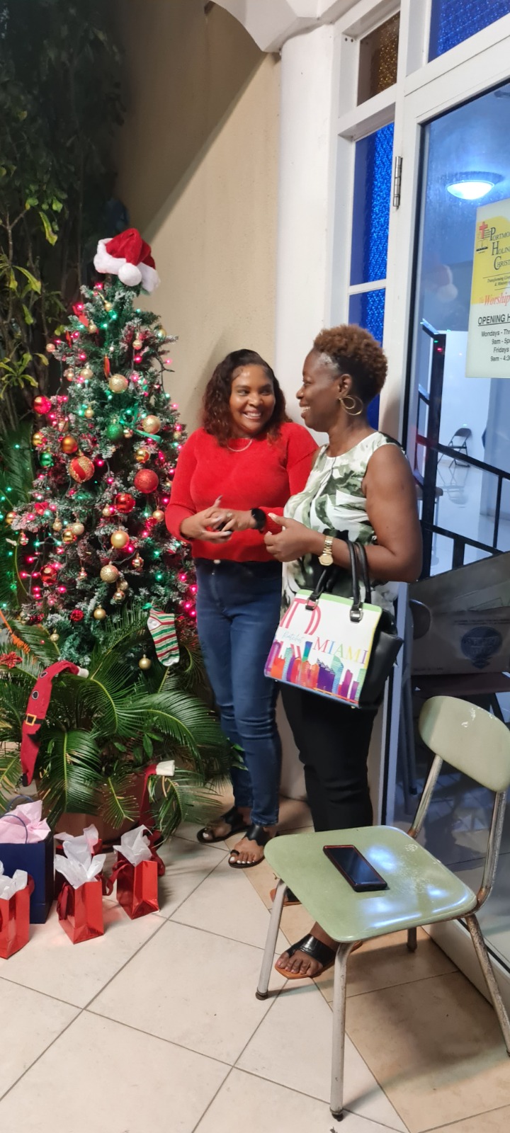 Two women sharing a conversation beside a decorated Christmas tree